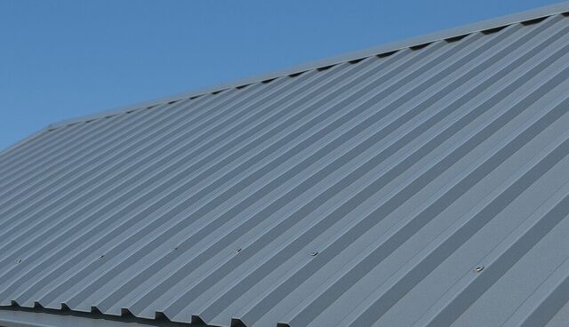 Telhado metálico cinza sob céu azul claro