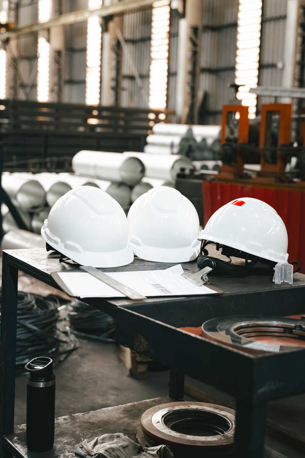 Capacetes de segurança brancos em uma mesa de trabalho